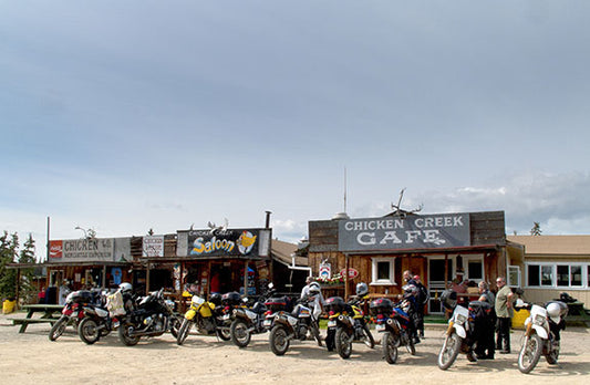 A line-up of off-road dirt bikes and a lone cruiser motorcycle in "downtown" Chicken, Alaska