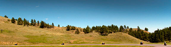 A line of motorcycle riders cruises through the area surrounding Sturgis, South Dakota