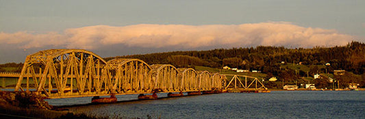 The railroad bridge between Nova Scotia’s Cape Breton Island and Boularderie Island gets a coat of orange/gold paint thanks to the setting sun.