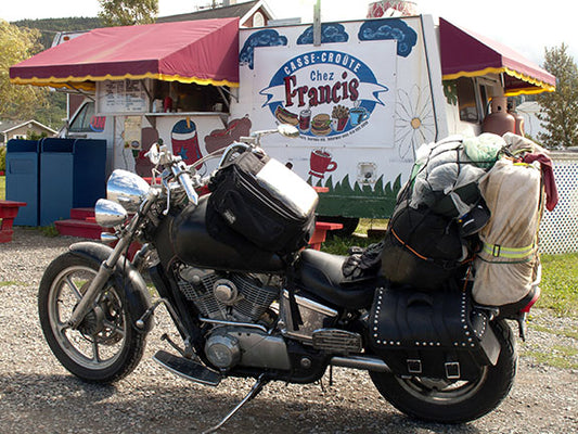 A 1995 Honda Shadow VT1100 sits at a grab-and-go take-out restaurant in Quebec, Canada