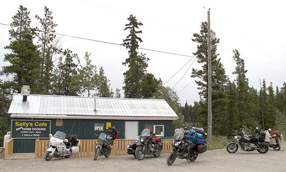 An array of motorcycles, from cruisers to dual-sport and touring machines, line up outside of Sally’s Cafe while riders refuel
