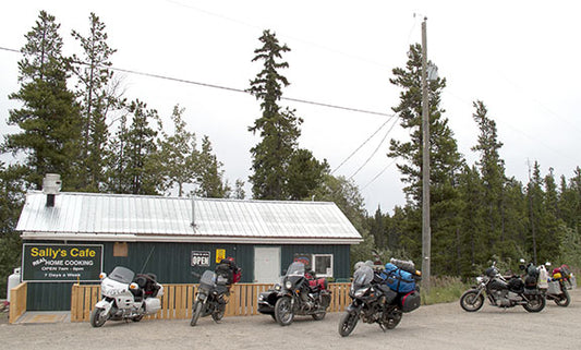 An array of motorcycles, from cruisers to dual-sport and touring machines, line up outside of Sally’s Cafe while riders refuel