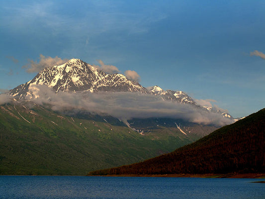A purplish gray cloud floats in front of Bashful Peak as the sun sets outside of Anchorage, Alaska.  