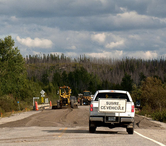 A lead vehicle guides photographer Geoffrey Kula and his 1995 Honda Shadow VT1100 motorcycle through a construction zone in northern Quebec, Canada.