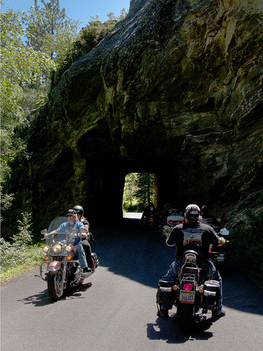 A group of motorcyclists take turns navigating a one-lane tunnel cut out of a South Dakota hillside during the Sturgis Motorcycle Rally.